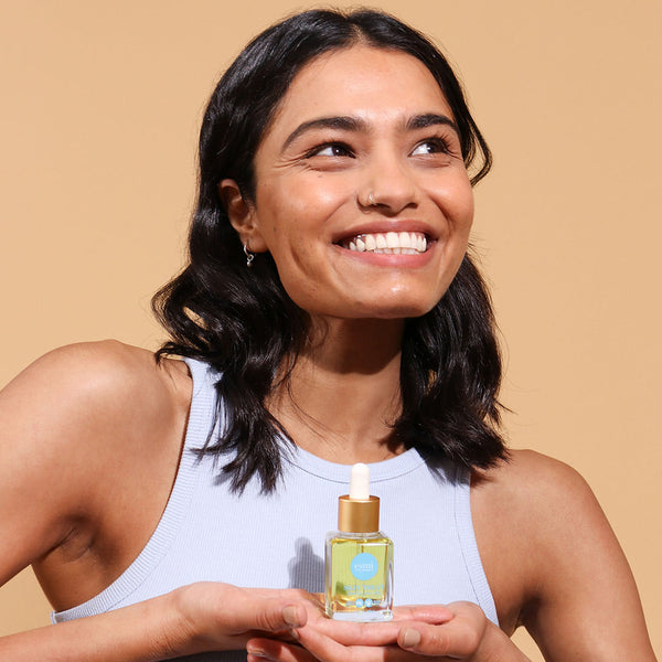 happy girl holding Acai Skin Balancing Face Oil
